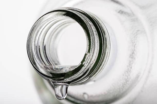 close up of water drop on glass bottle, on white background